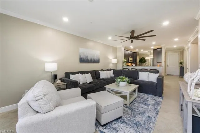 a living room with furniture and a view of kitchen