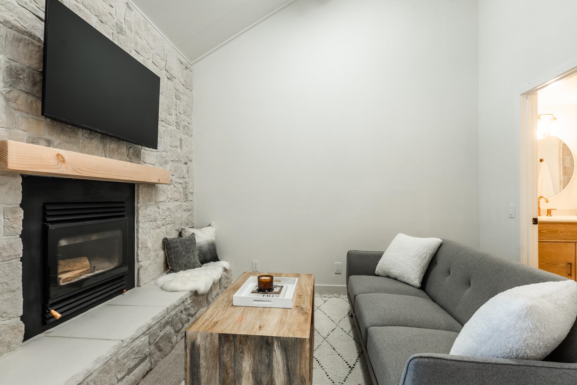 2289 Sierra Nevada Road, Unit F15 Mammoth Lakes, CA 93546 - Photo 5 of 44 a living room with a fireplace a flat screen tv and a window