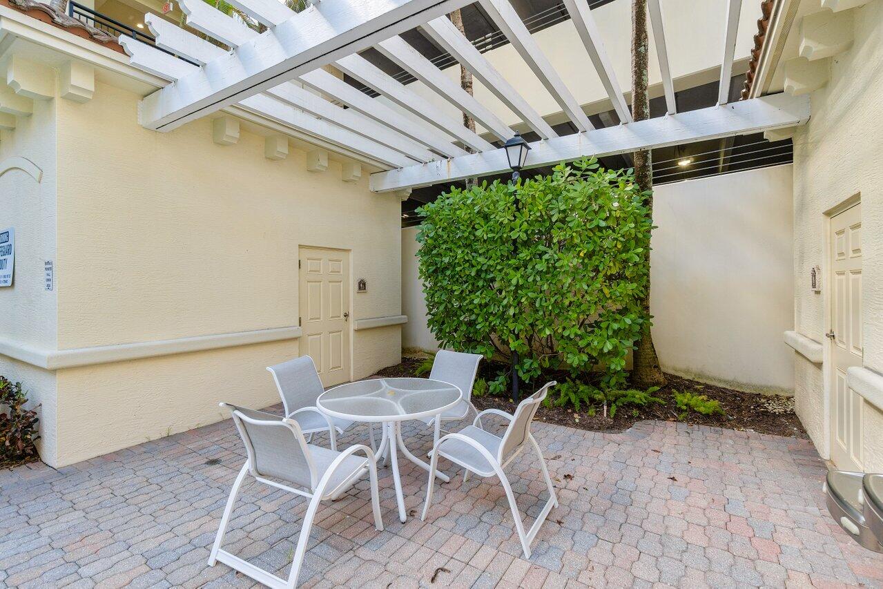 1 Renaissance Way, Unit 416 Boynton Beach, FL 33426 - Photo 20 of 31 a patio with table and chairs and potted plants