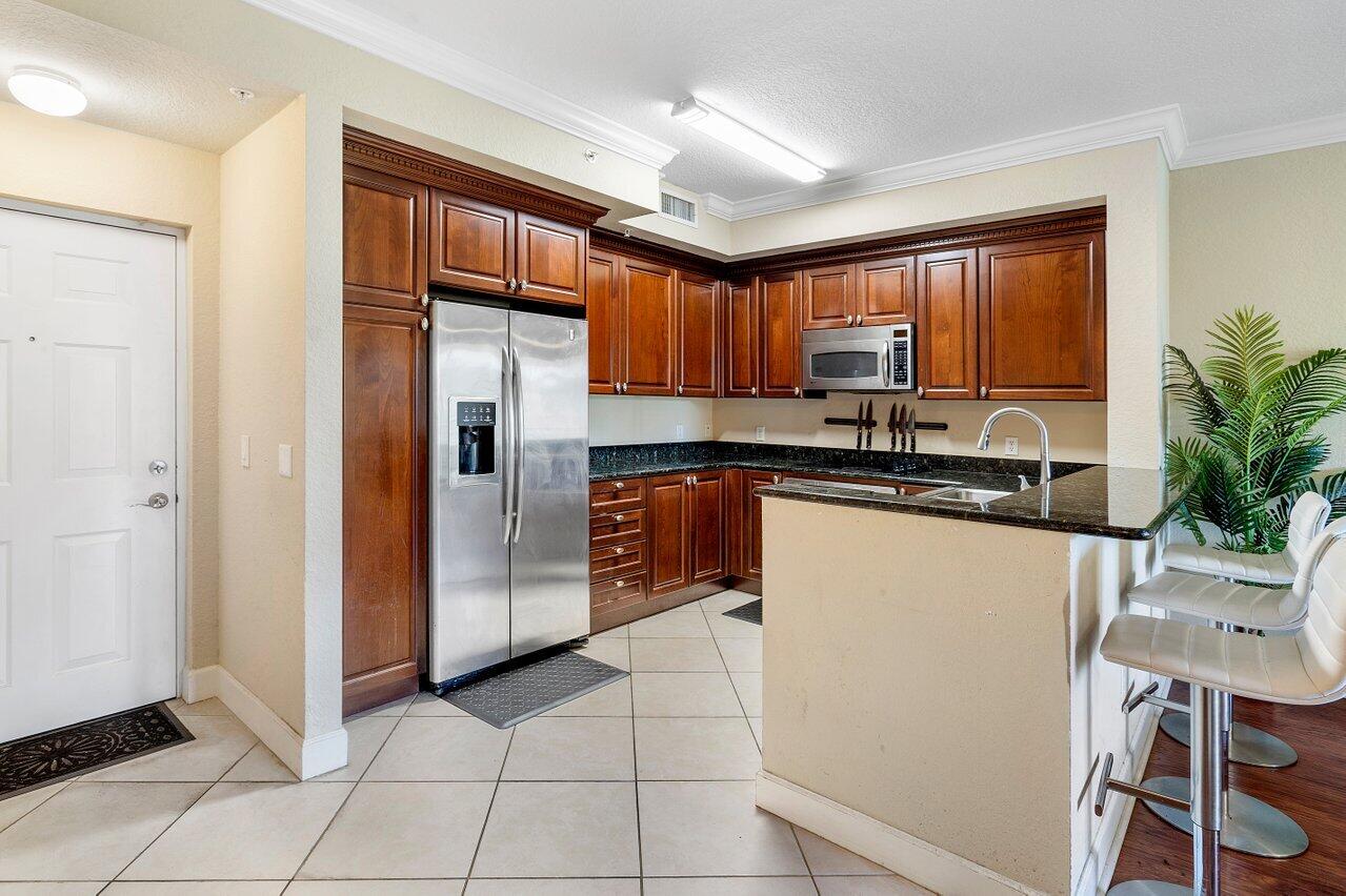 1 Renaissance Way, Unit 416 Boynton Beach, FL 33426 - Photo 6 of 31 a kitchen with granite countertop a refrigerator a stove a sink and cabinets