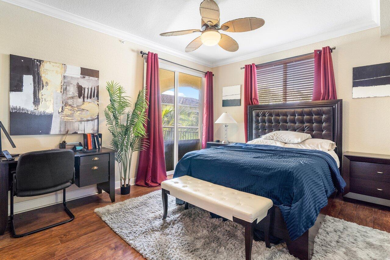 1 Renaissance Way, Unit 416 Boynton Beach, FL 33426 - Photo 9 of 31 a bedroom with a bed a chandelier and a window