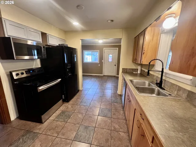 a kitchen with granite countertop a refrigerator and a sink