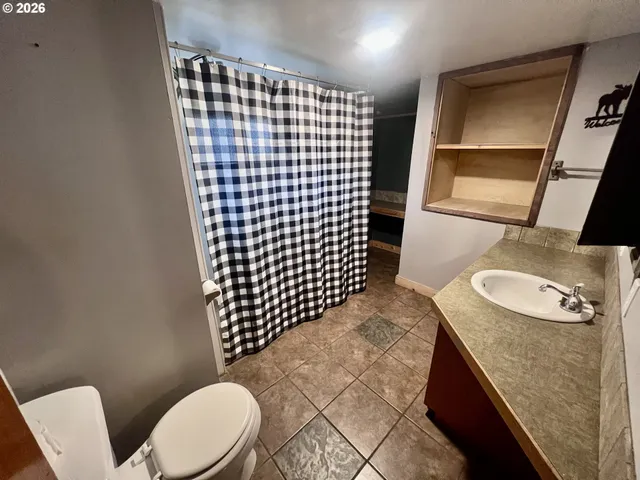 a bathroom with a granite countertop toilet sink and mirror