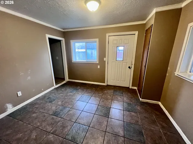 a view of an empty room with window and bathroom