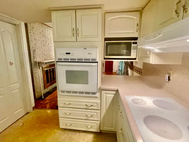 a kitchen with white cabinets and refrigerator