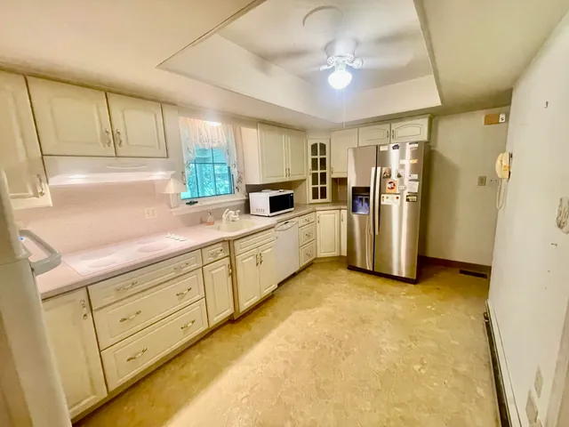 a kitchen with granite countertop cabinets appliances and a sink