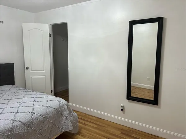 a bedroom with a bed and wooden floor