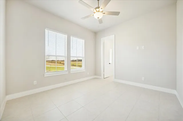 an empty room with a window and a fan