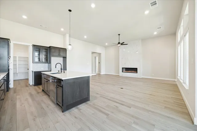 a kitchen with stainless steel appliances a sink and wooden floor