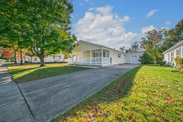 a view of house with a big yard and potted plants