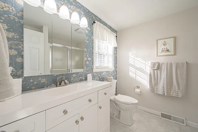 a bathroom with a double vanity sink toilet and a mirror