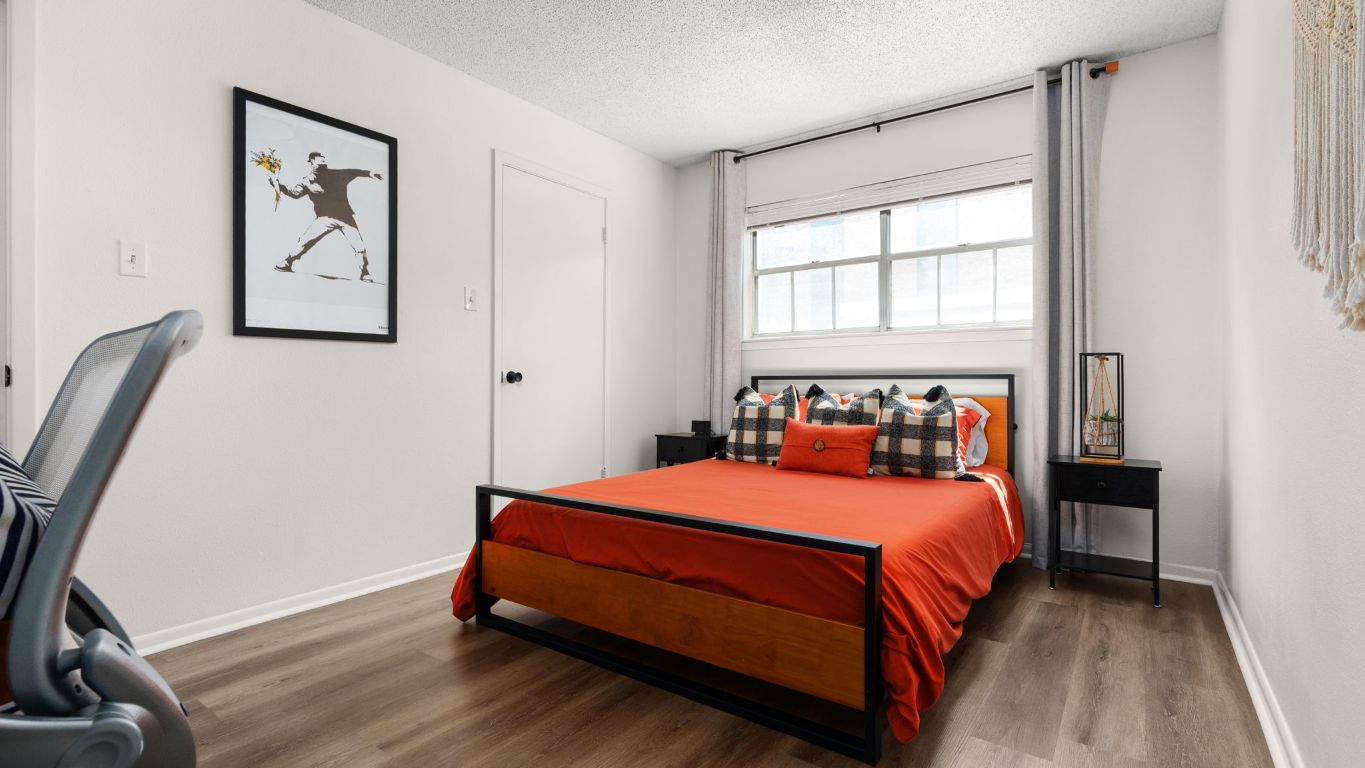 8730 North Mopac Expressway, Unit 109 Austin, TX 78759 - Photo 13 of 21 a bedroom with a bed and wooden floor