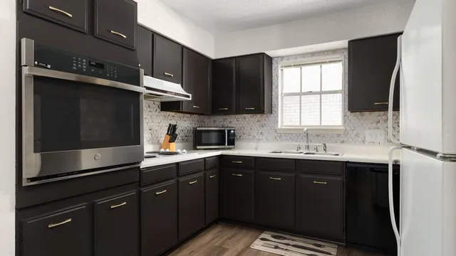 a kitchen with a sink a window and stainless steel appliances