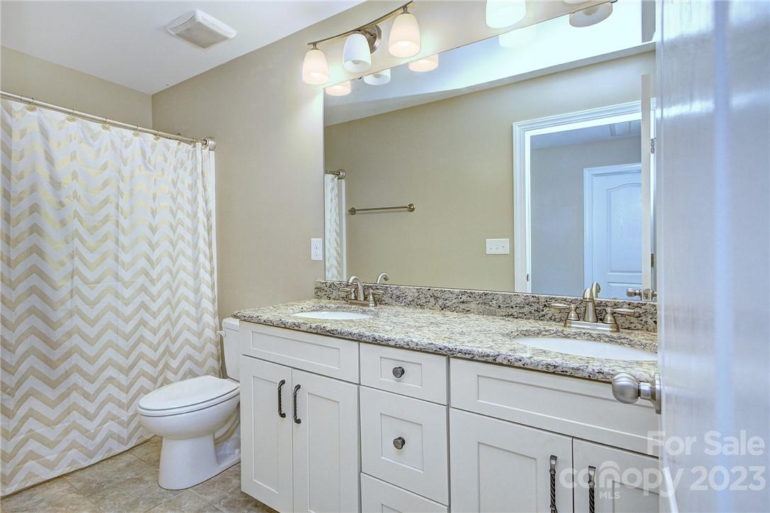 160 Kentmere Lane Clover, SC 29710 - Photo 30 of 37 a bathroom with a granite countertop sink toilet a mirror and shower curtain
