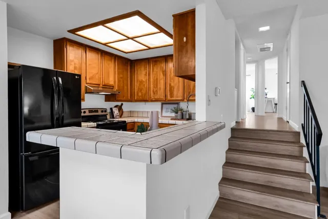 a kitchen with stainless steel appliances granite countertop a sink a stove and a refrigerator