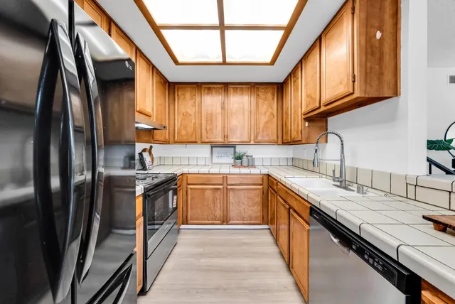 a kitchen with stainless steel appliances granite countertop sink stove top oven and cabinets