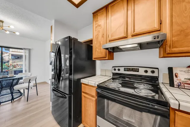 a kitchen with stainless steel appliances granite countertop a sink a stove and a wooden floors