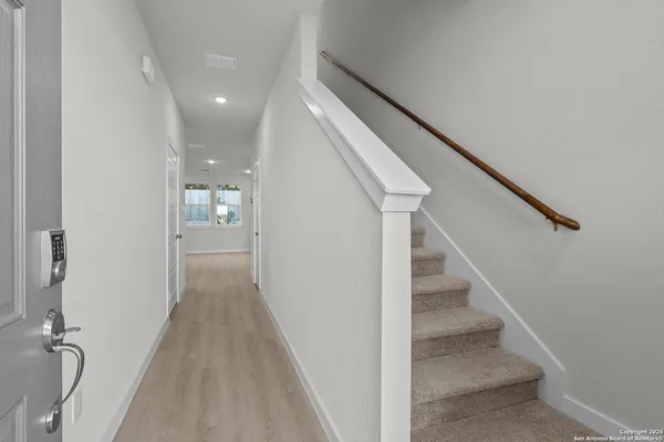 a view of a hallway with wooden floor and staircase