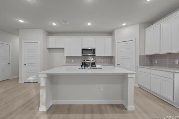 a kitchen with kitchen island granite countertop wooden cabinets and a stove