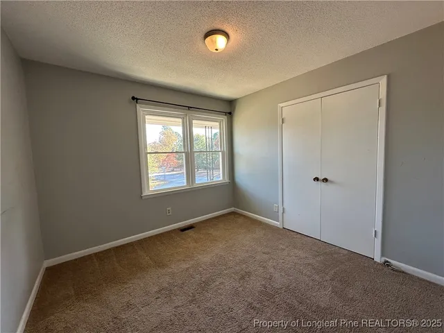 an empty room with windows and closet