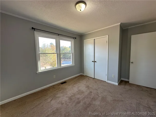 an empty room with windows and closet