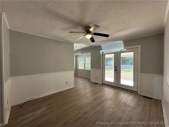 a view of an empty room with window and wooden floor