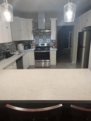 a kitchen with kitchen island a sink a stove and refrigerator