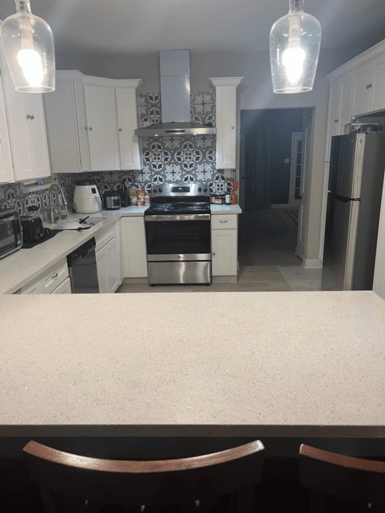 6716 Jefferson Boulevard Groves, TX 77619 - Photo 11 of 34 a kitchen with kitchen island a sink a stove and refrigerator
