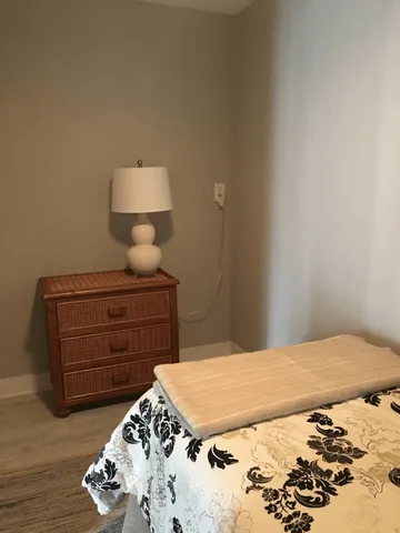 a bedroom with a bed and a lamp on dresser