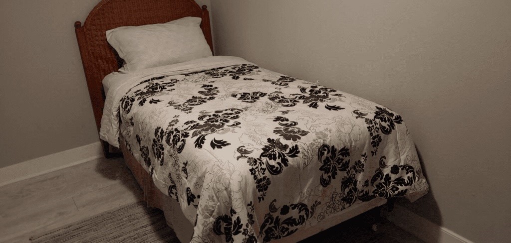 6716 Jefferson Boulevard Groves, TX 77619 - Photo 26 of 34 a bed with a black and white comforter