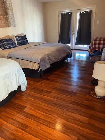 a bedroom with bed and wooden floor