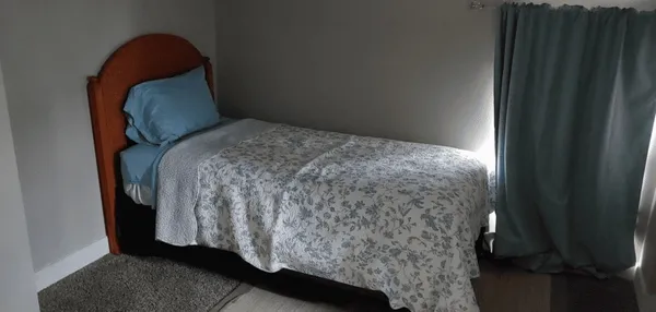 a bed sitting in a bedroom next to a window