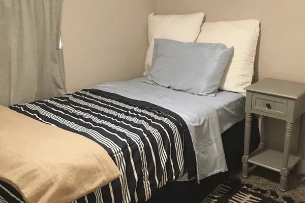 a bed sitting in a bedroom next to a window