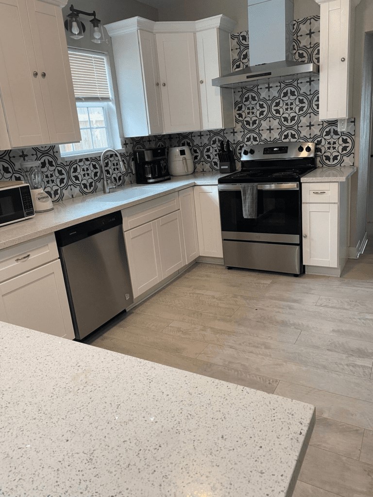 6716 Jefferson Boulevard Groves, TX 77619 - Photo 6 of 34 a kitchen with stainless steel appliances granite countertop a stove a sink and white cabinets