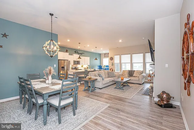a living room with couches a dining table and chairs with wooden floor
