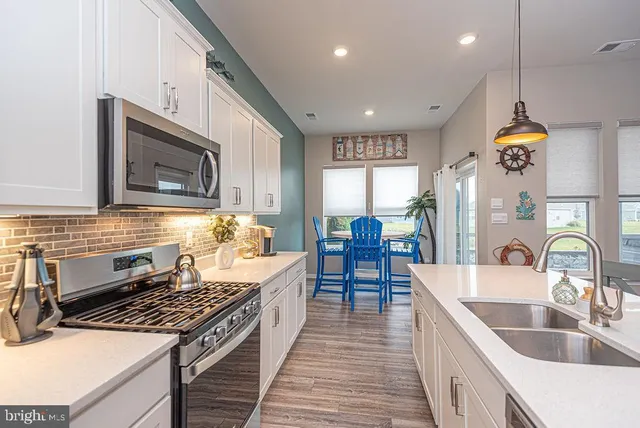 a kitchen with sink stove and cabinets