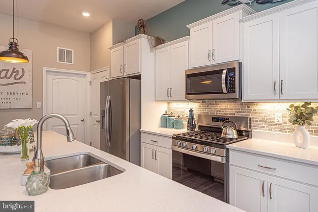 a kitchen with refrigerator a stove a sink and a microwave