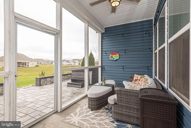 a living room with furniture and a floor to ceiling window
