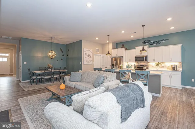 a living room with lots of furniture and kitchen view
