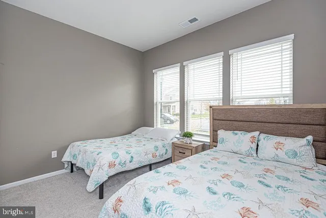 a bedroom with two beds and a large window