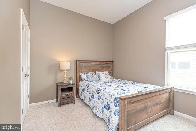 a bed sitting in a bedroom next to a window