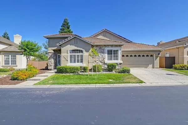 a front view of a house with a yard and garage