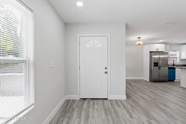 a kitchen with stainless steel appliances white cabinets and wooden floors