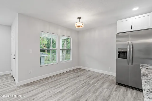 a kitchen with granite countertop a sink stove cabinets and refrigerator