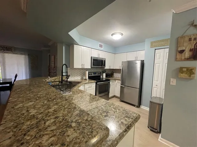 a kitchen with refrigerator and microwave