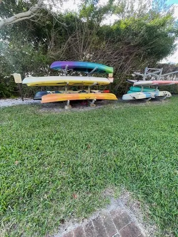 a view of swimming pool with lawn chairs and large trees