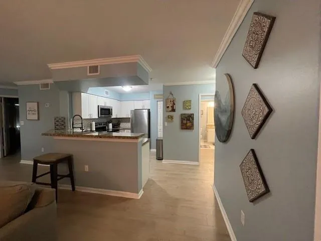 a view of kitchen with sink and refrigerator