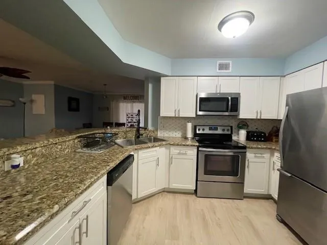 a kitchen with a sink appliances and cabinets