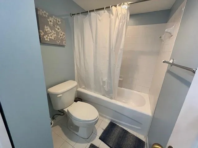 a white toilet sitting next to a bath tub