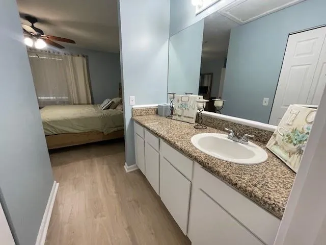 a en suite bathroom with a granite countertop sink and a mirror